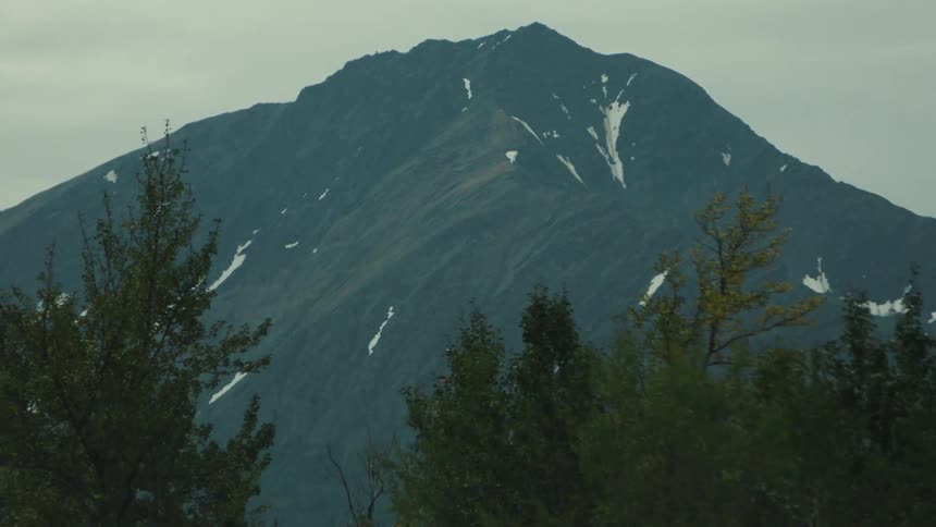 Rocky mountain surrounded by trees outdoors in cloudy water