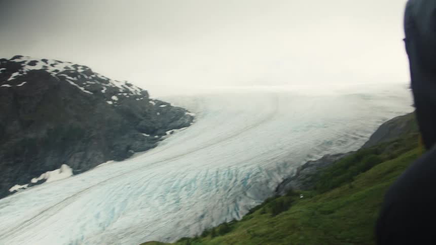 A person wearing a winter coat near a snowcovered mountain in winter