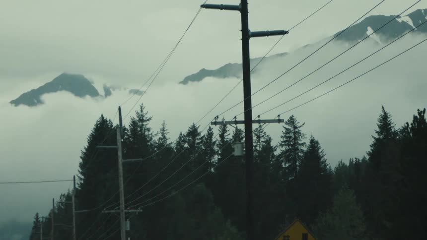 The tall power lines run past the mountain and forest