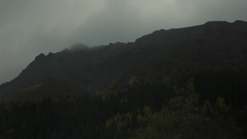 Mountains shrouded in mist under a cloudy sky
