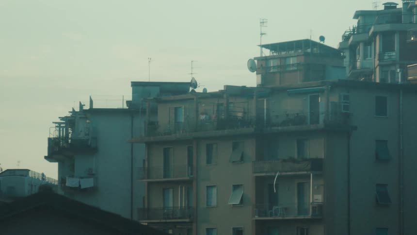 The apartment buildings line the cloudy sky