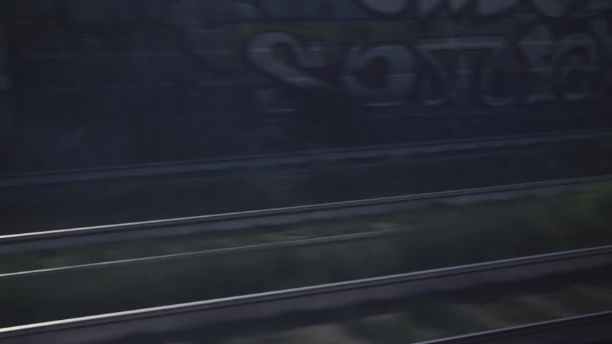 Graffiti covers the wall by the tracks