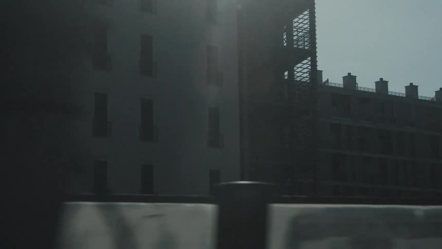 Dark buildings contrast with the bright sky in an urban area