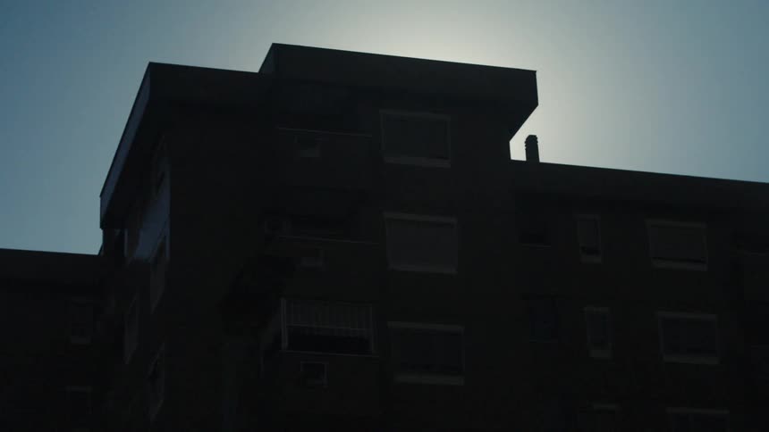 Silhouette of metal structure against bright sky with strong sun flare