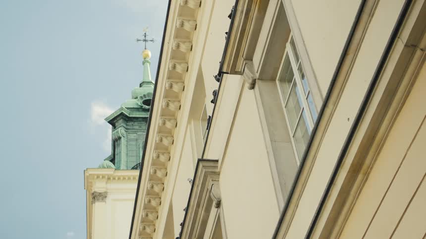Architectural details of a classical building next to a tower with a green dome