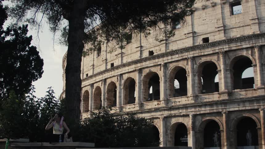 The woman stands out front of the coliseum