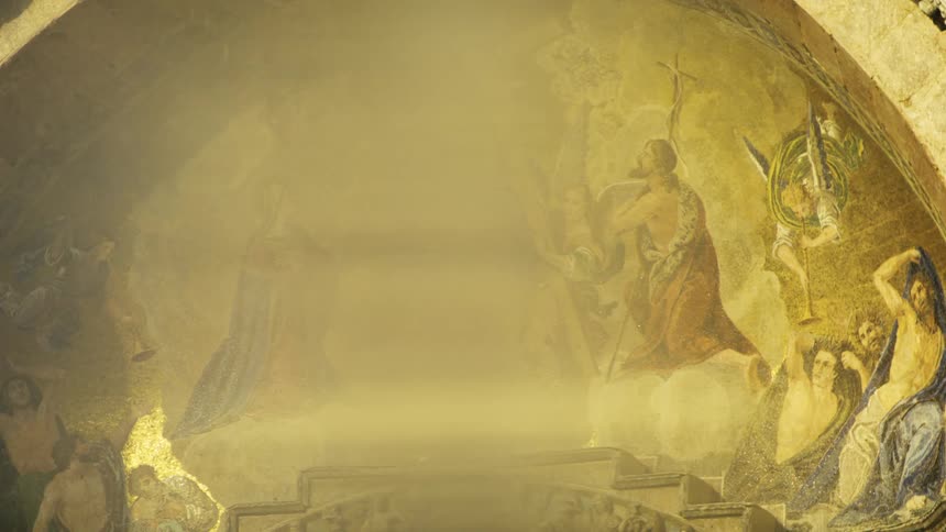 Sun shines on the painting under the arch of the church