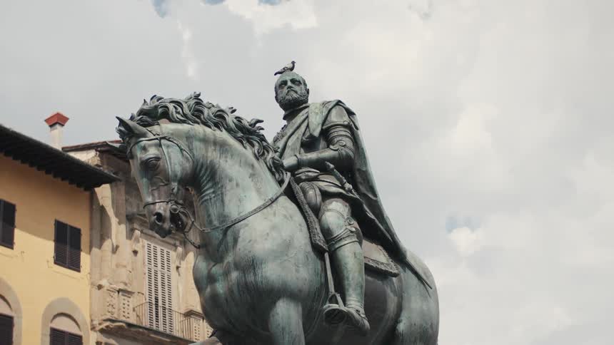 Monumental sculpture of a horse with its rider stationed in a city during daytime