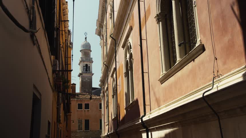 A dome tower building at the end of an alley in city during daytime