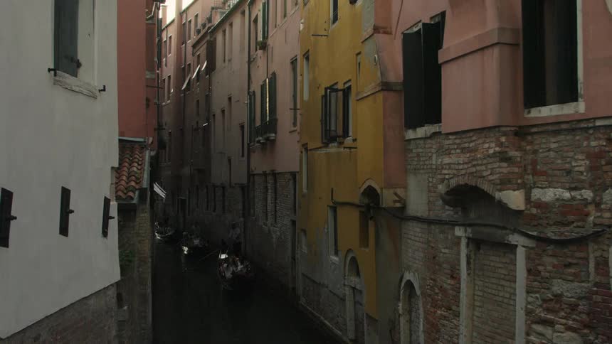 Boats are docked in the canal near the building