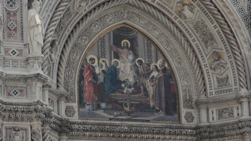 Religious mosaic in pointed arch with central figure raising arms surrounded by haloed saints