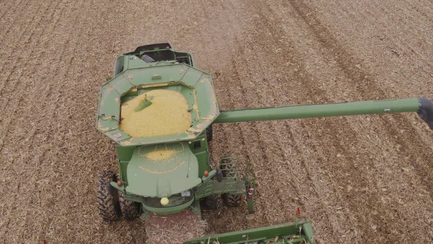 Combine harvester working on a field of crops outdoors during day time