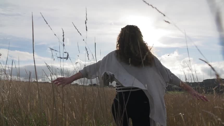 Woman walking through a grassy field