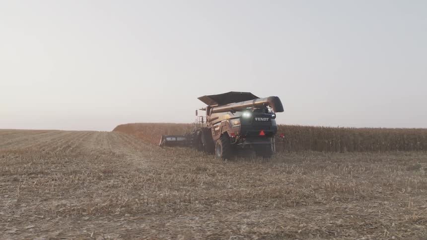 Combine harvester advancing through the field during corn harvest