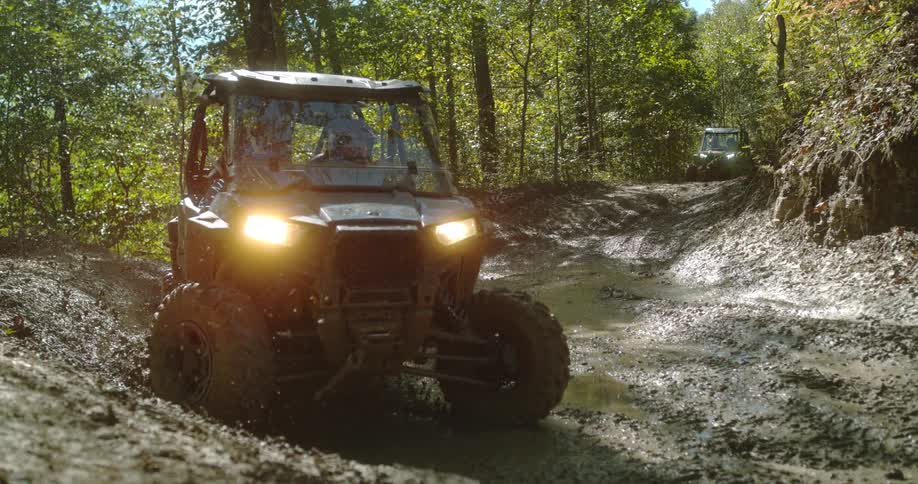 The off road vehicles drive through the mud