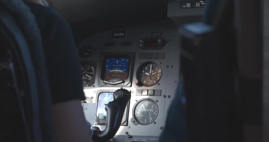 The pilot is sitting in the cockpit flying the plane