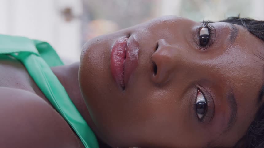 Closeup of a woman lying down with a serene gaze and soft expression