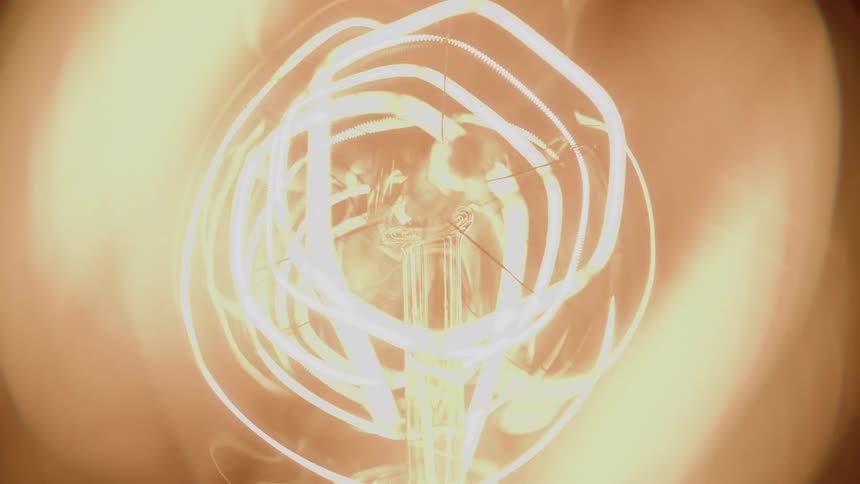 Closeup of a glowing filament emitting intense light inside a bulb