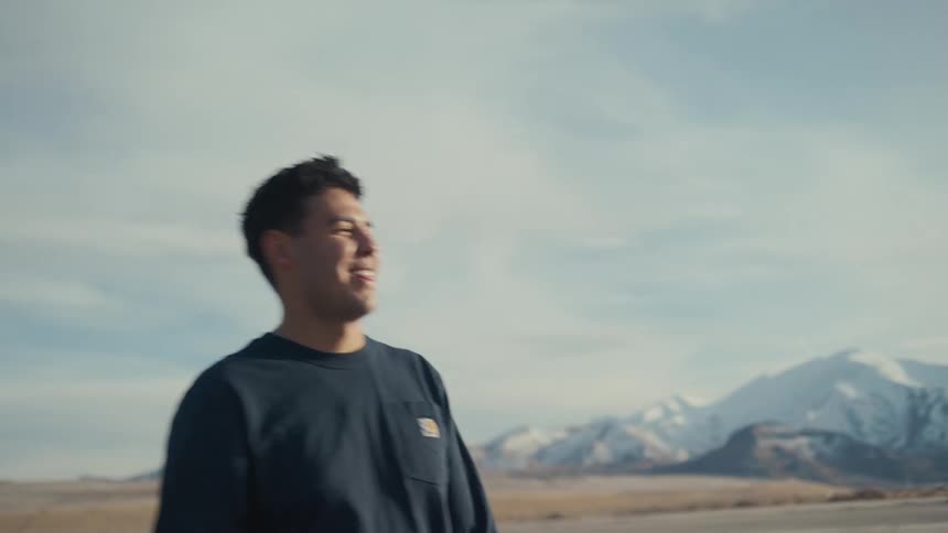Couple sharing a close gaze with mountains in the background under a clear sky
