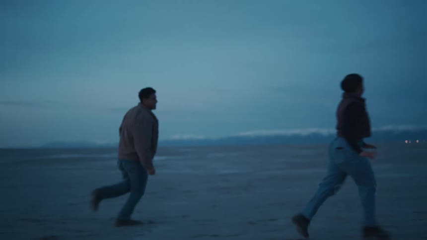 Couple runs and plays together on a flat landscape at sunset