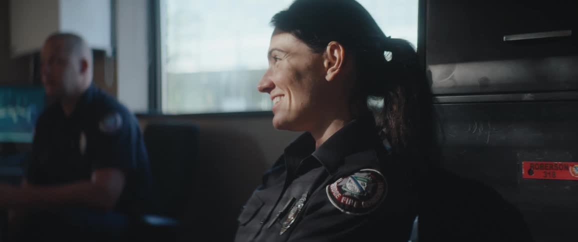 The police officer is sitting and laughing