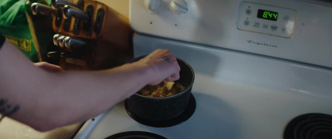 The person mixes the food in the pot