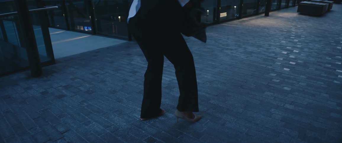 Woman walking in an urban area and taking off her high heels