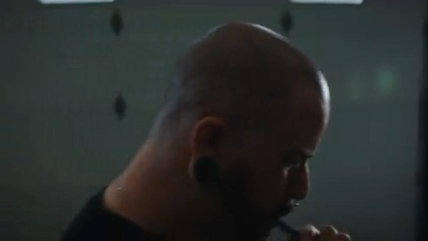 Bald man pacing in an indoor space