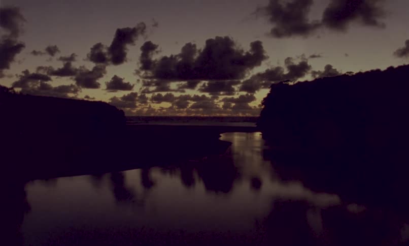 River reflecting the evening sky between dark hills