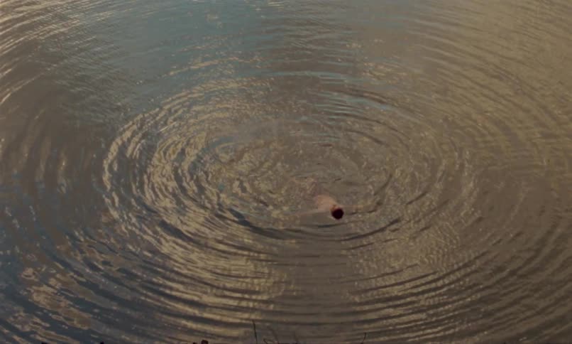Male person swimming outdoors during dusk or dawn