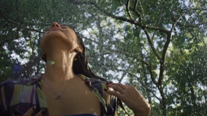 Rain is pouring on the woman in the woods