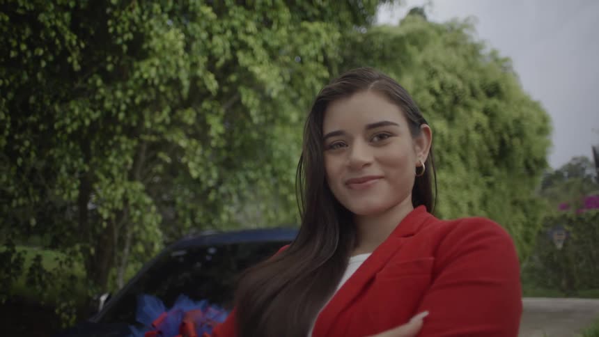 Close up portrait of a happy young woman standing outdoors while holding her car key