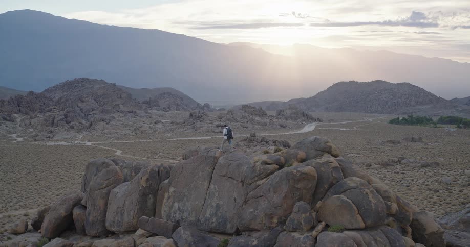 The man is hiking on the mountain top on a foggy day
