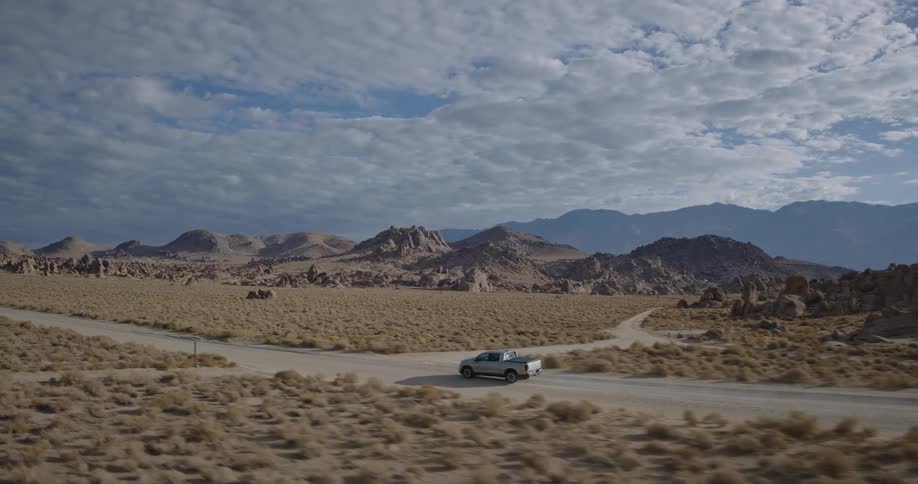 The pickup truck drives on a trail through the desert