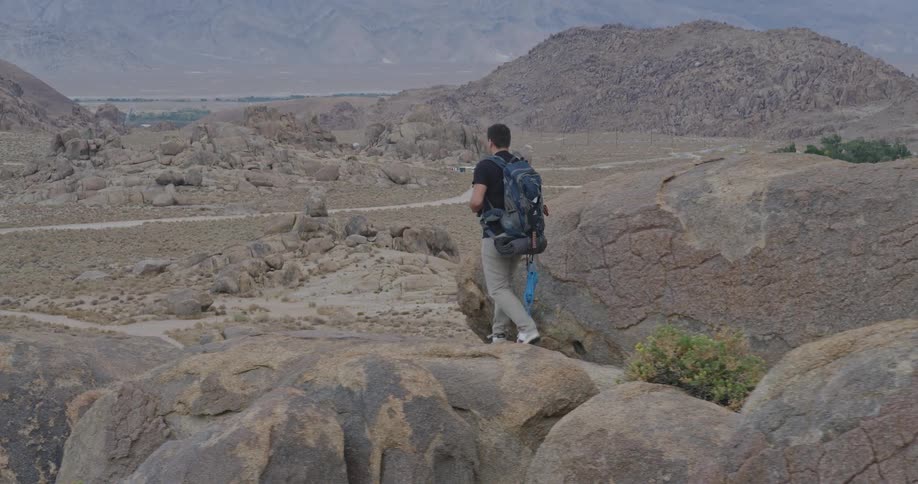 The man climbs up over the boulders