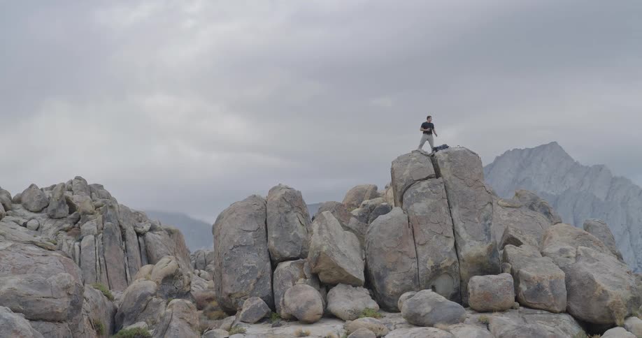 The man stands on the mountain on a cloudy day