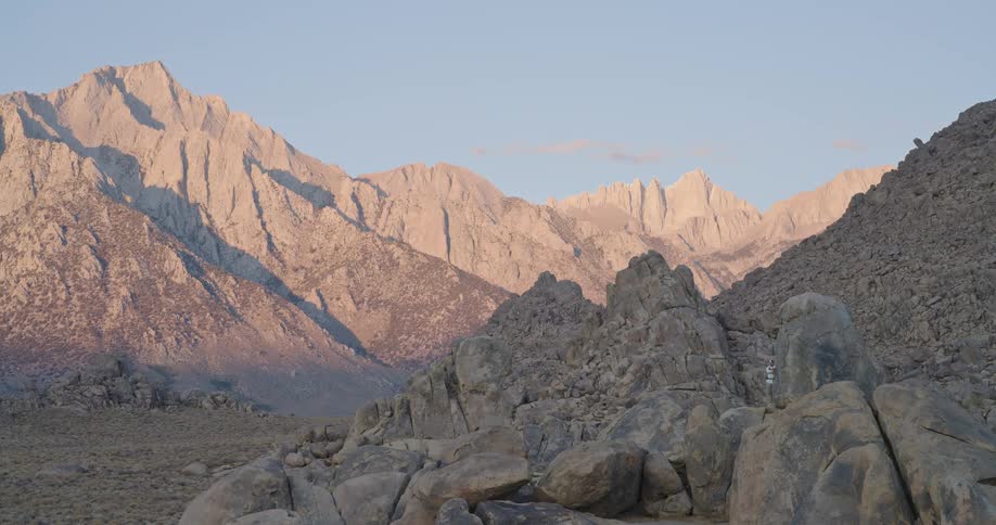 The man stands on pile of boulders on a sunny day