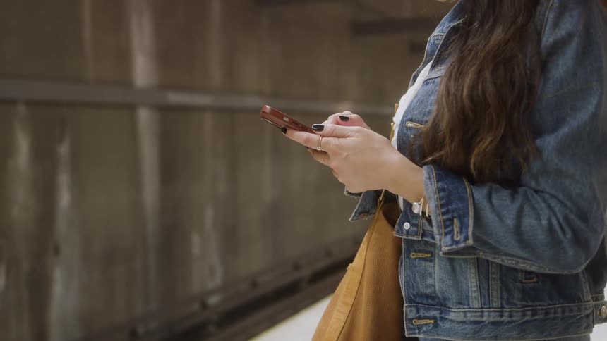 Young woman standing up and using a smart phone
