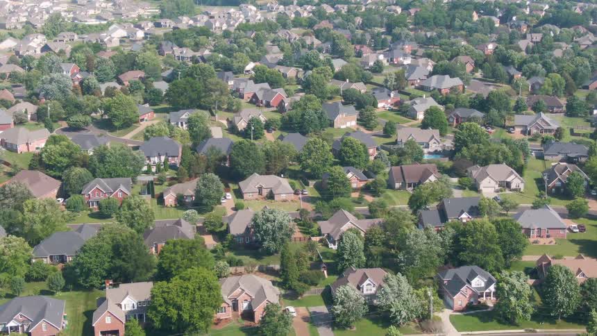 Aerial view of residential neighborhood with singlefamily homes organized streets and green spaces