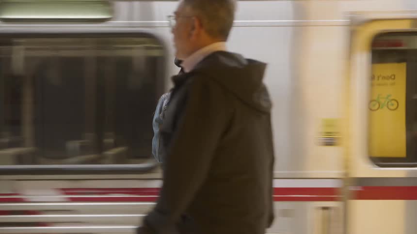Woman standing on platform as train moves past