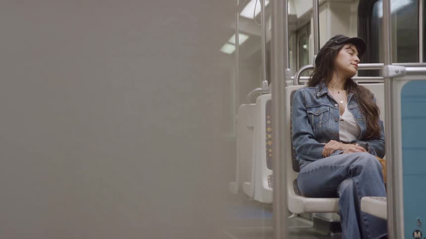 Relaxed female riding on a metro looking out the window
