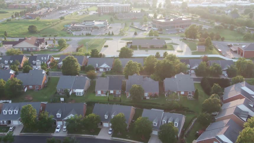 River runs past a residential neighborhood on a hazy summer day