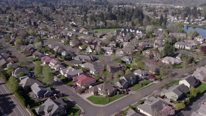 Residential neighborhood with aligned houses and treelined streets seen from above