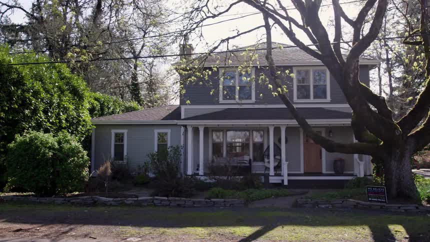 Twostory house with porch and large tree in front yard