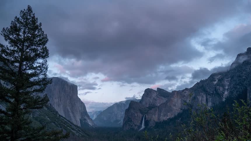 The waterfall pours off the mountain