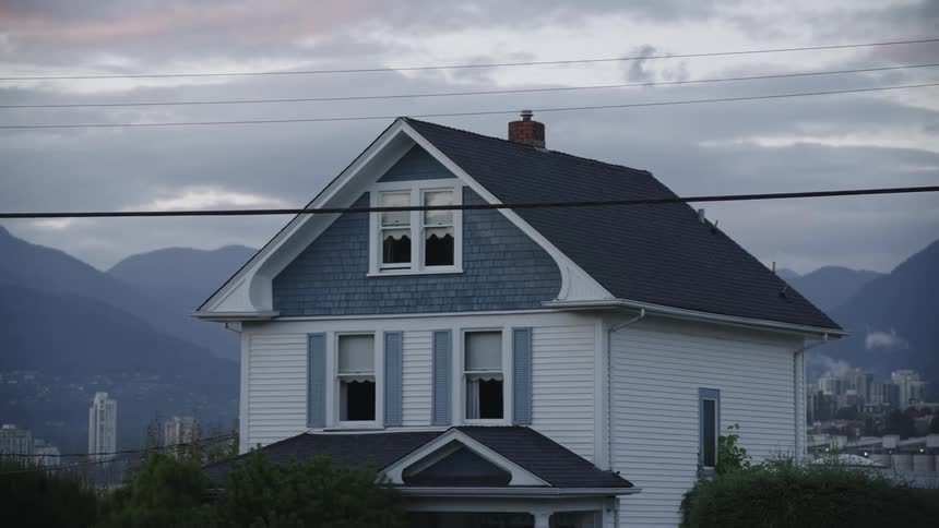 House with gable roof and broken windows in neighborhood overlooking mountains