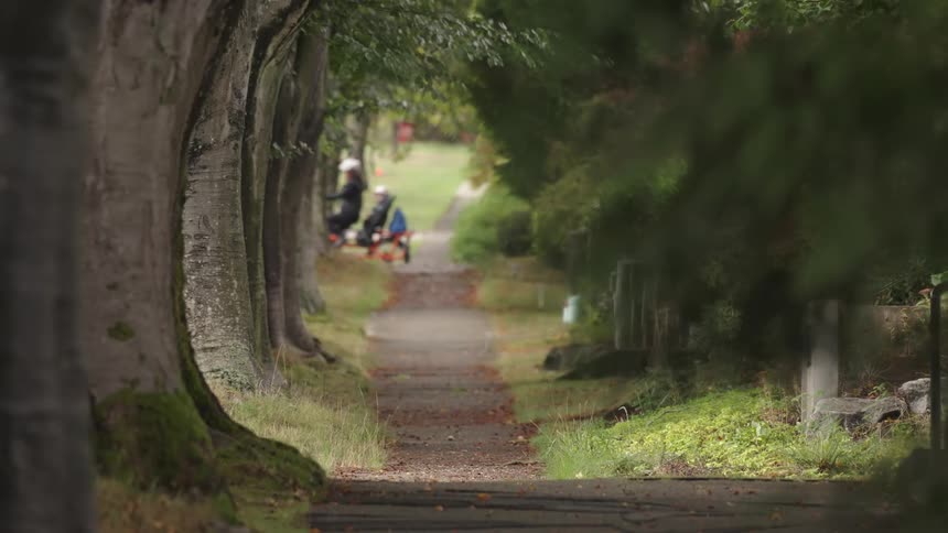 People ride on a two seated bike through the park