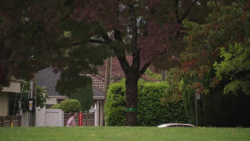 The woman jogs past the homes