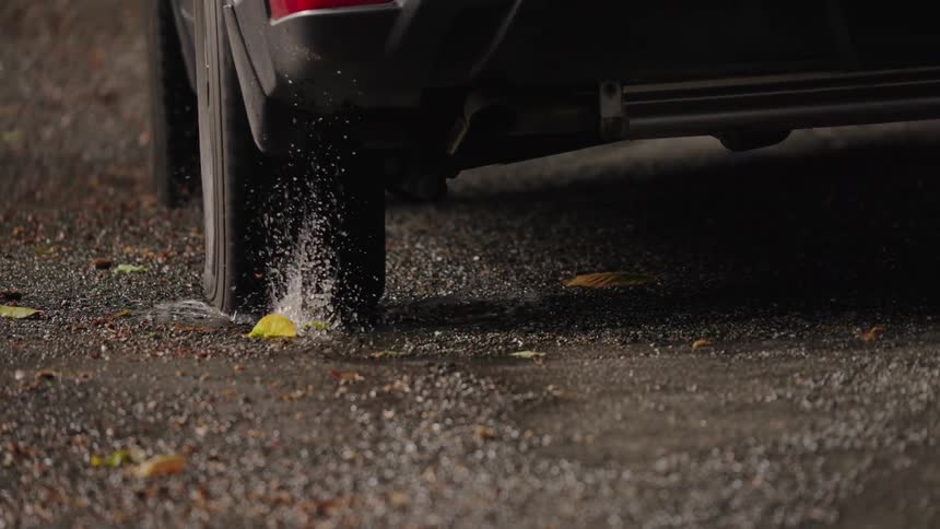 Close up of a vehicle driven outdoors on a wet road during daytime