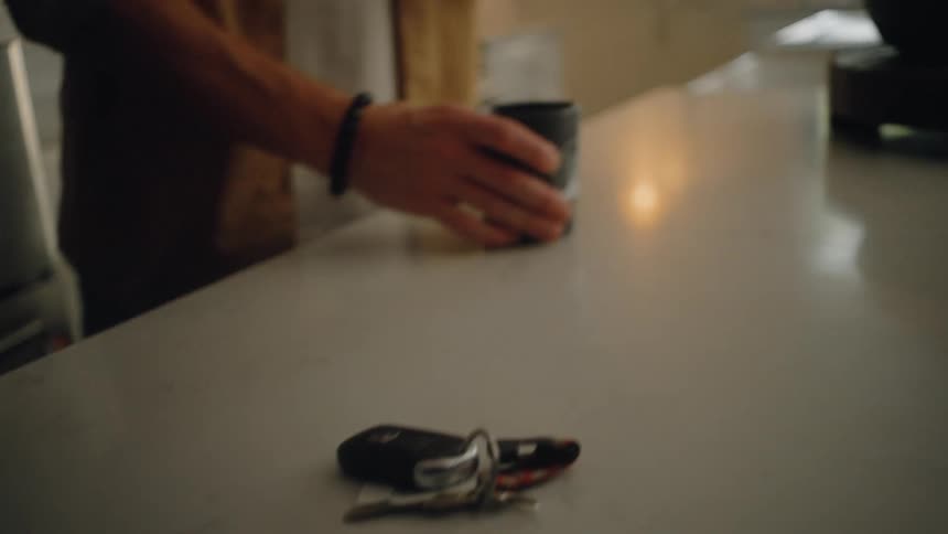 Person picking up a car key from a bench